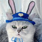Cat wearing knit blue bunny pet hat with pink ears