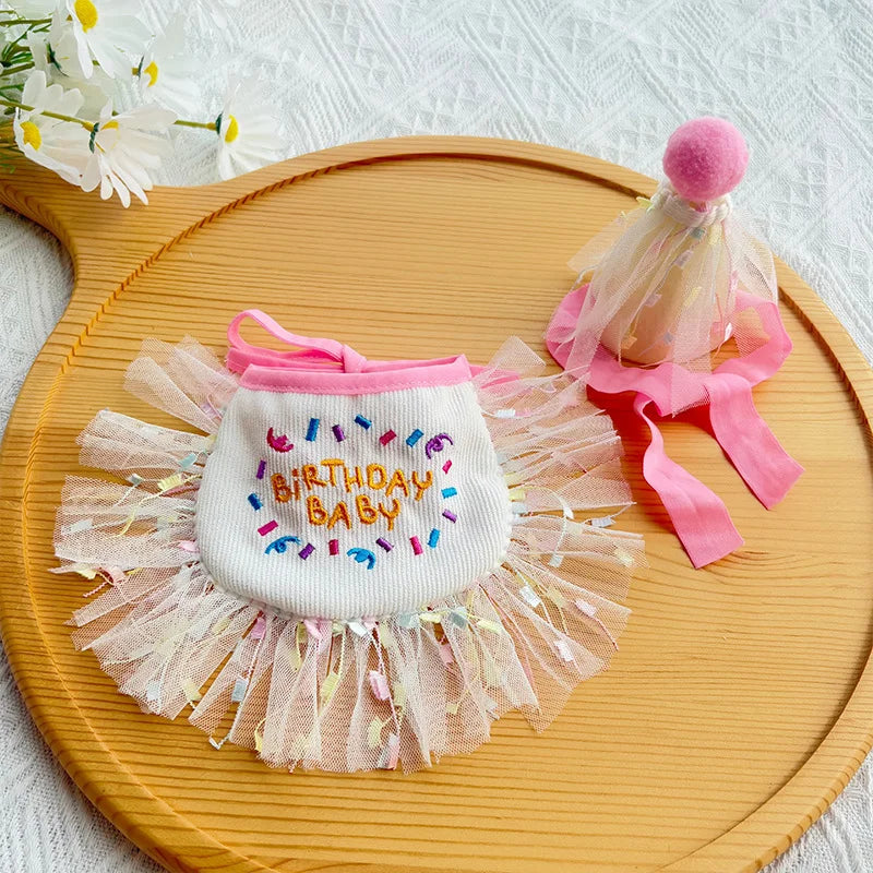 Flat-lay of pink birthday bib and matching tulle party hat